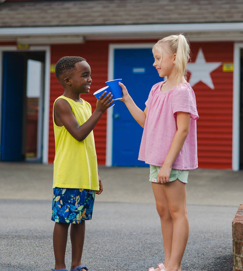 Two children enjoying Free Unlimited Soft Drinks outside a Pepsi Oasis