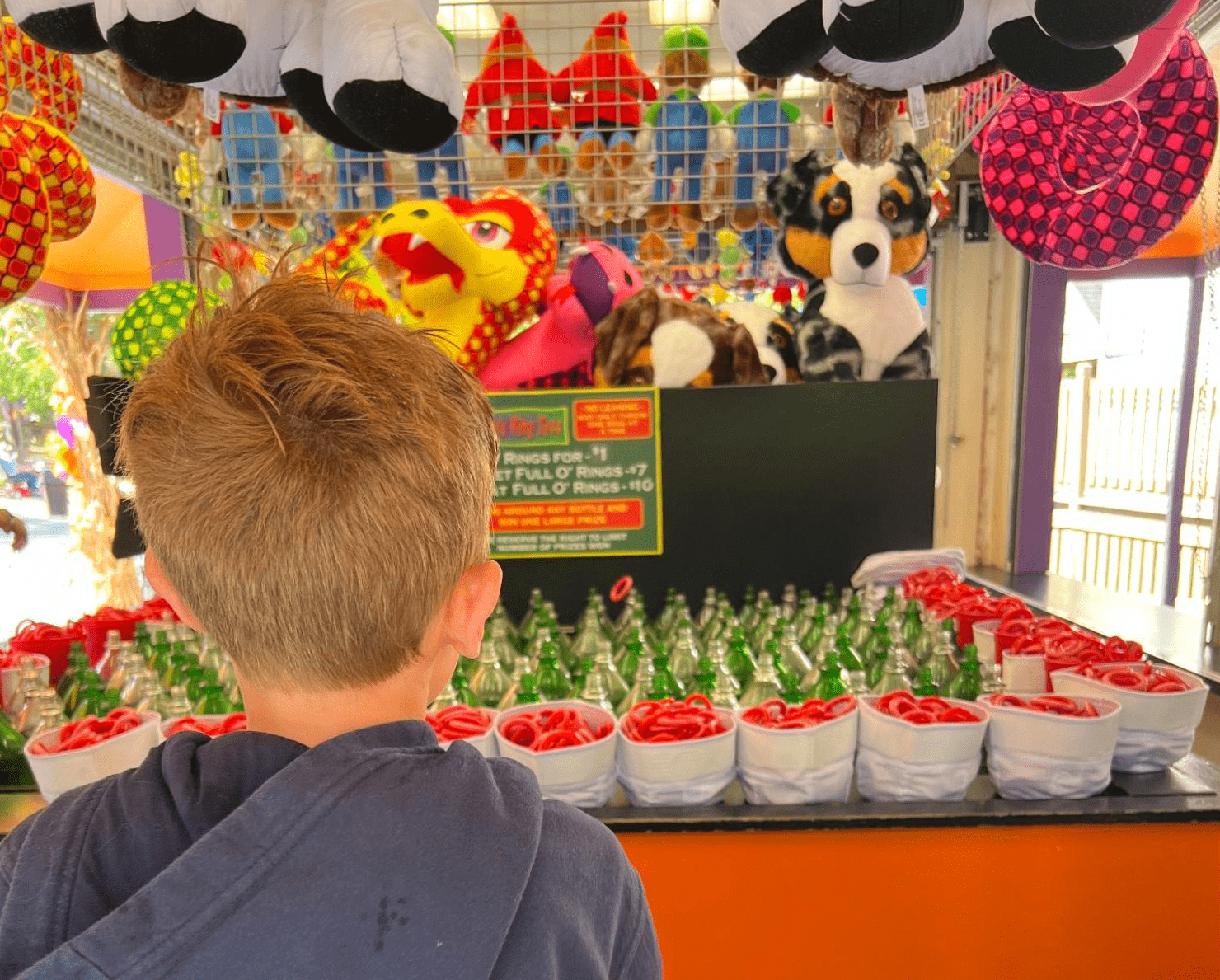 A young boy trying his luck at Raven's Ring Toss