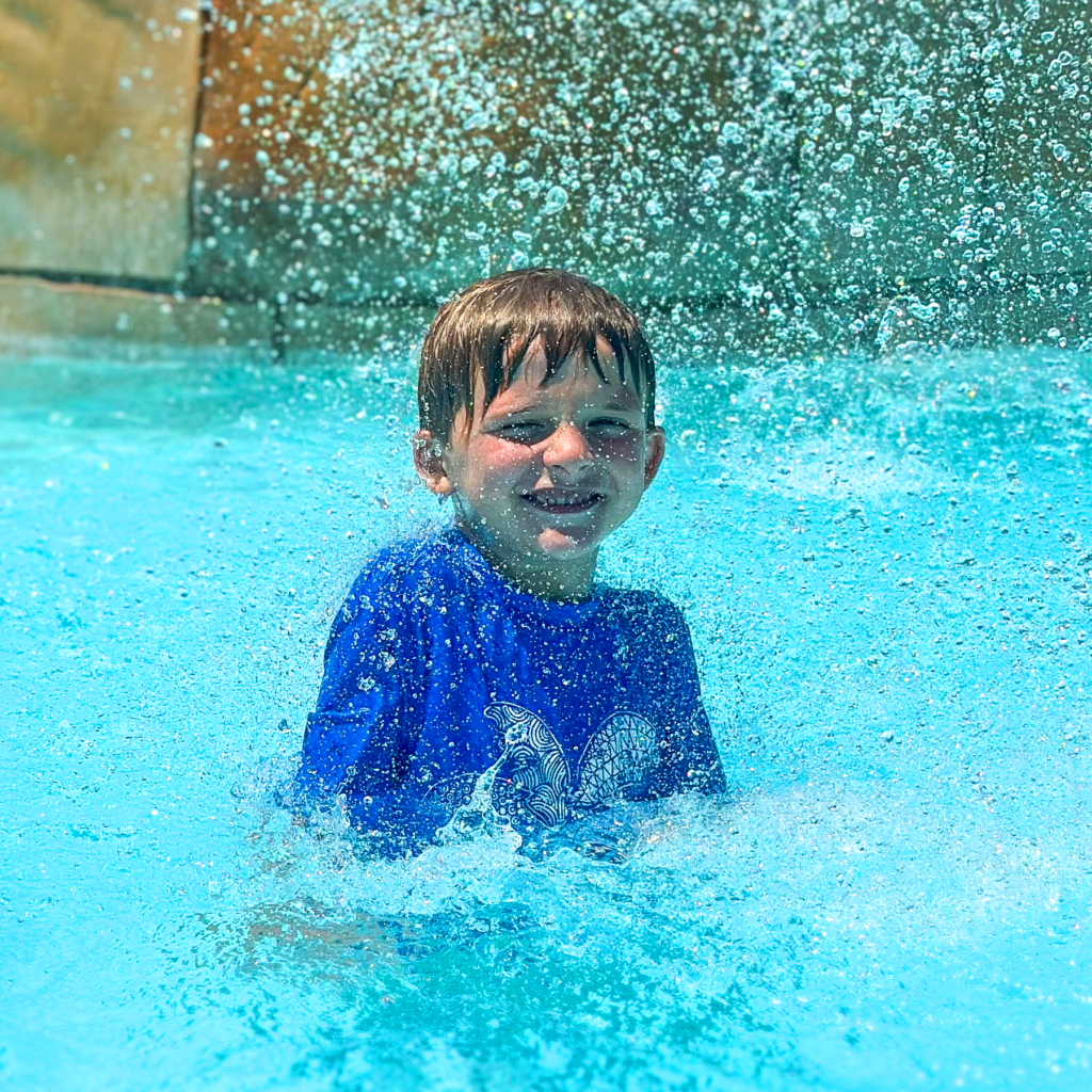 HoliBlogger Trina's youngest son under falling water.