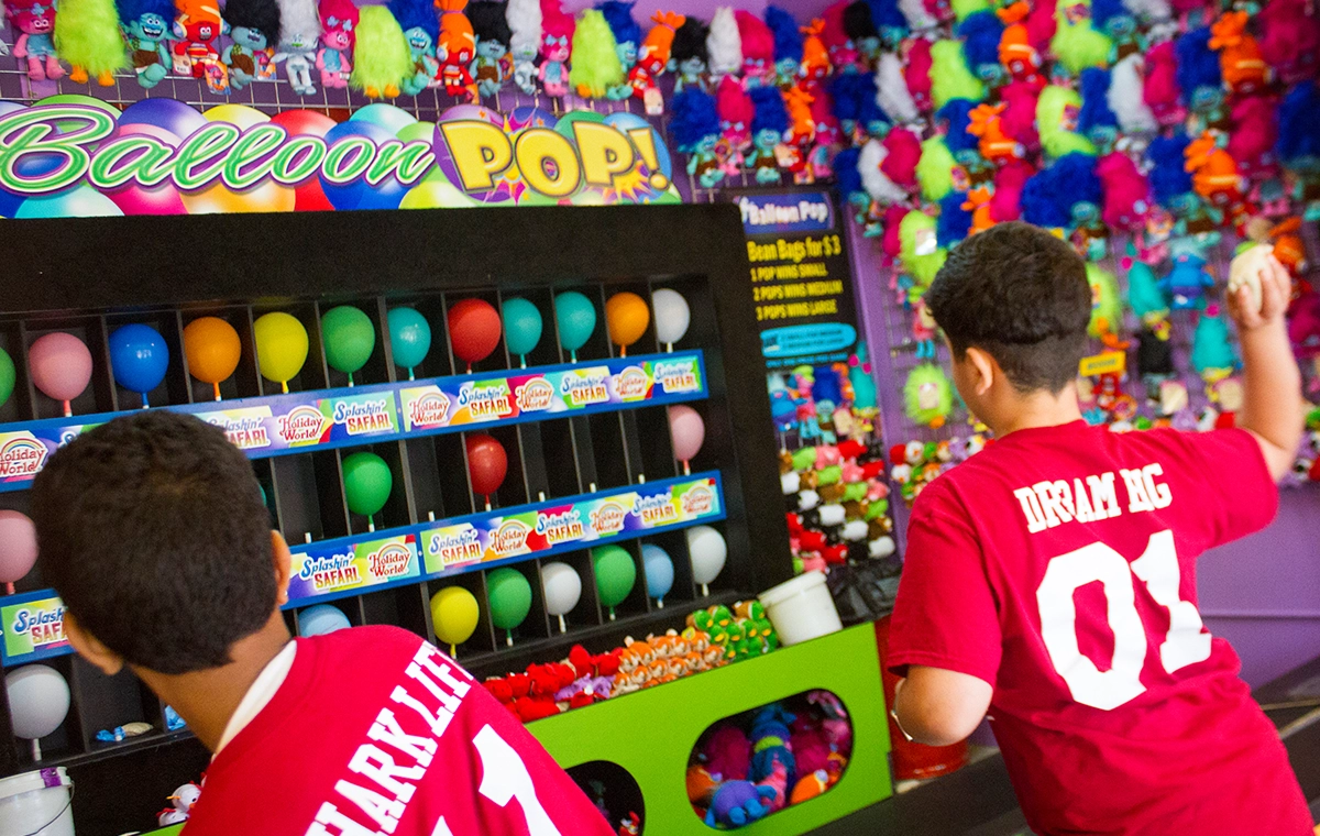 Two boys aiming their bean bags at Boo's Balloon Pop at Holiday World.