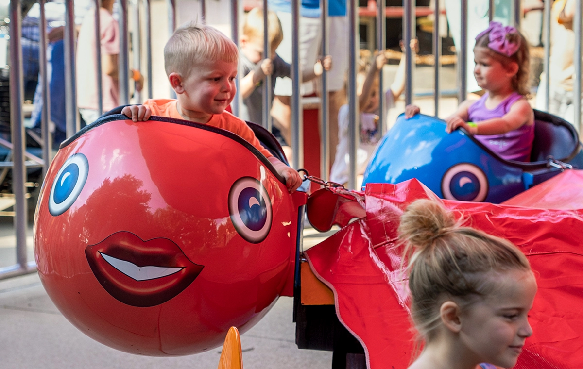 A young boy with an adorable grin while riding Dancer's Fish at Holiday World & Splashin' Safari in Santa Claus, Indiana.
