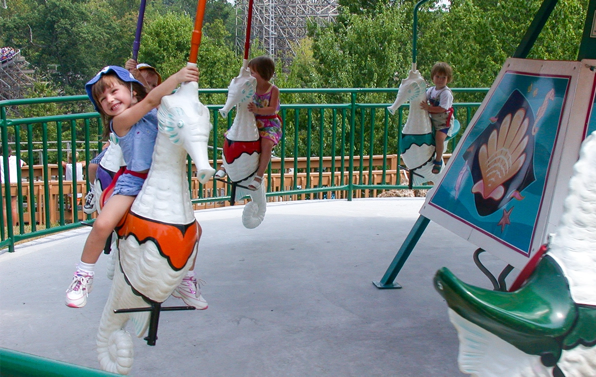 A child smiling big while spinning around on Dasher's Seahorses at Holiday World & Splashin' Safari in Santa Claus, Indiana.