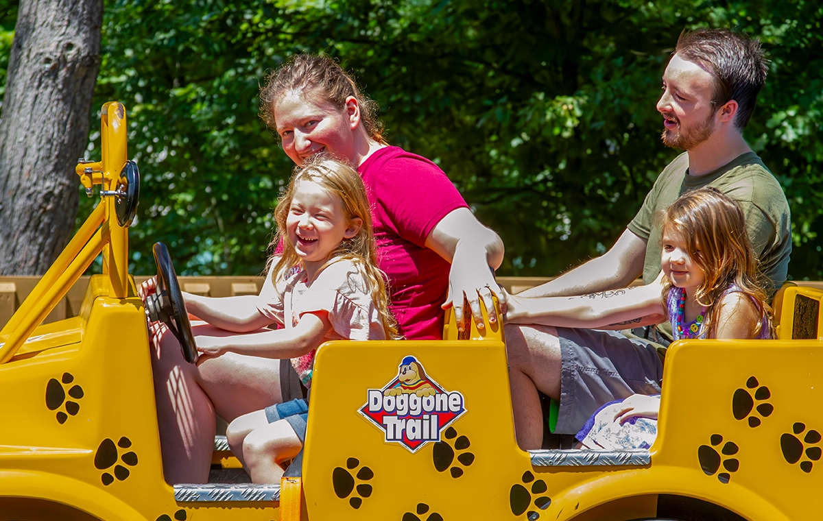 A young girl smiles big while riding Doggone Trail at Holiday World & Splashin' Safari in Santa Claus, Indiana.