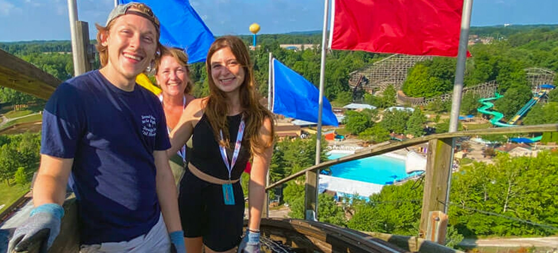 Three people at the top of the Voyage lift hill while on a Guided Tour.
