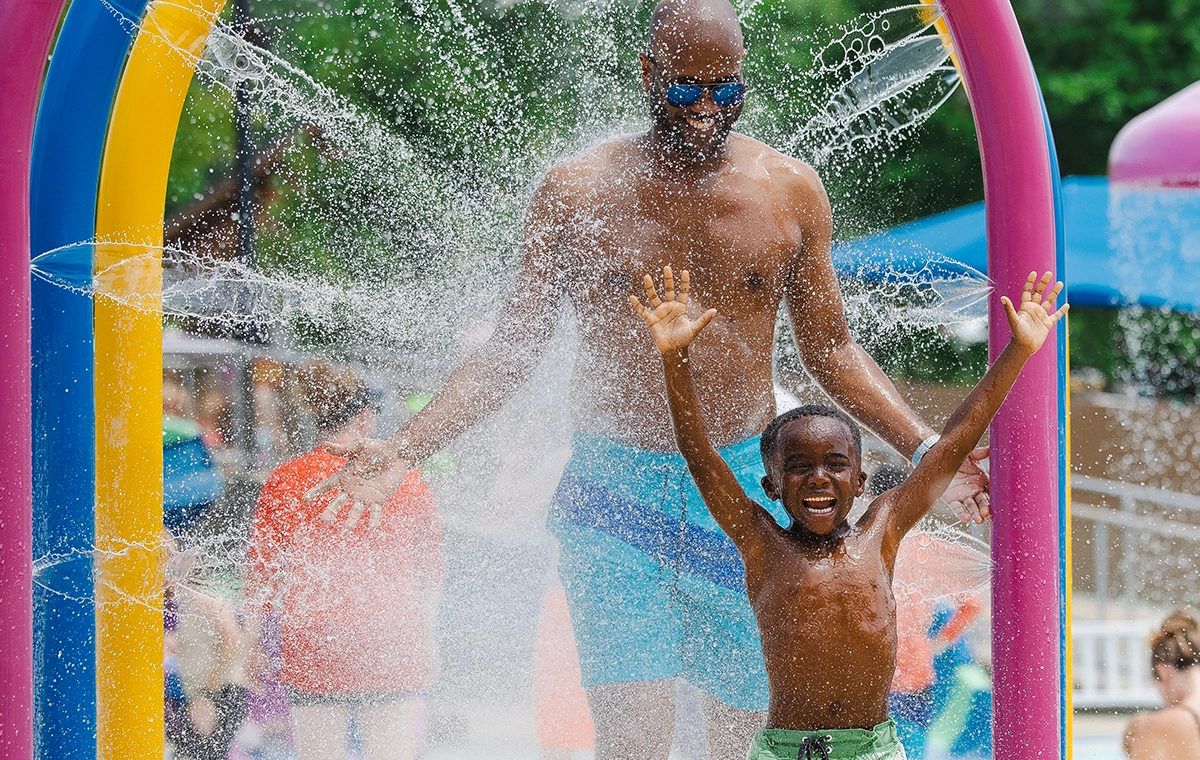 Father and son enjoying the spraying arches at Safari Sam's SplashLand at Holiday World & Splashin' Safari in Santa Claus, Indiana.