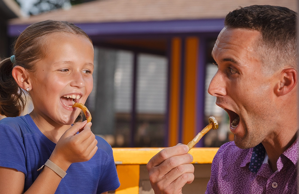 A father and daughter enjoy exclusive food items during Summer Wine'd Down at Holiday World.