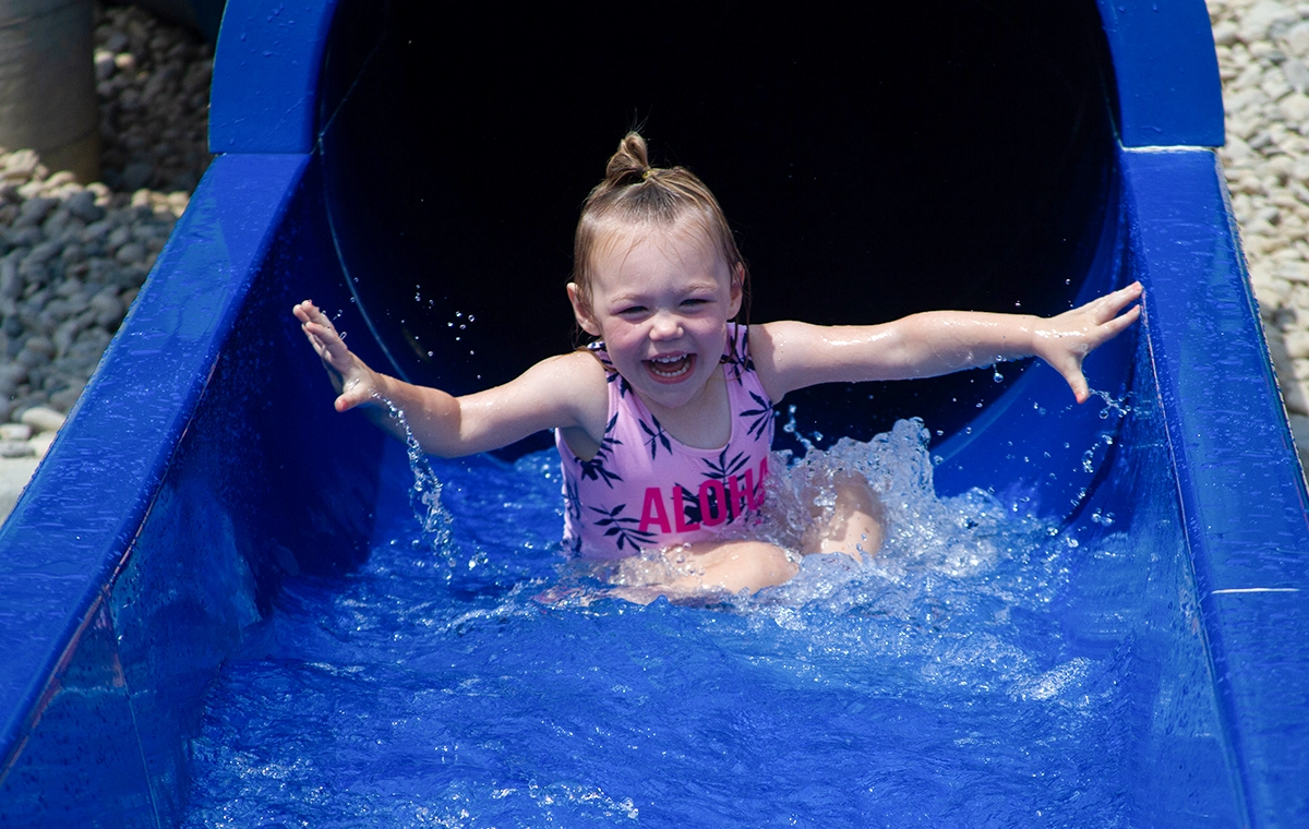 A young girl splashes down out of the blue slide of Tembo Falls at Holiday World & Splashin' Safari in Santa Claus, Indiana.