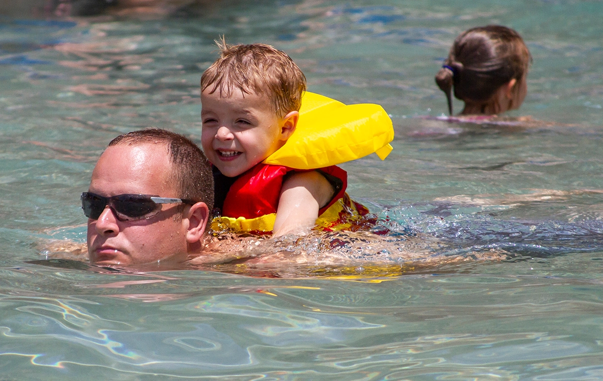 A young boy rides piggyback on his dad in Tembo Tides at Holiday World & Splashin' Safari in Santa Claus, Indiana.