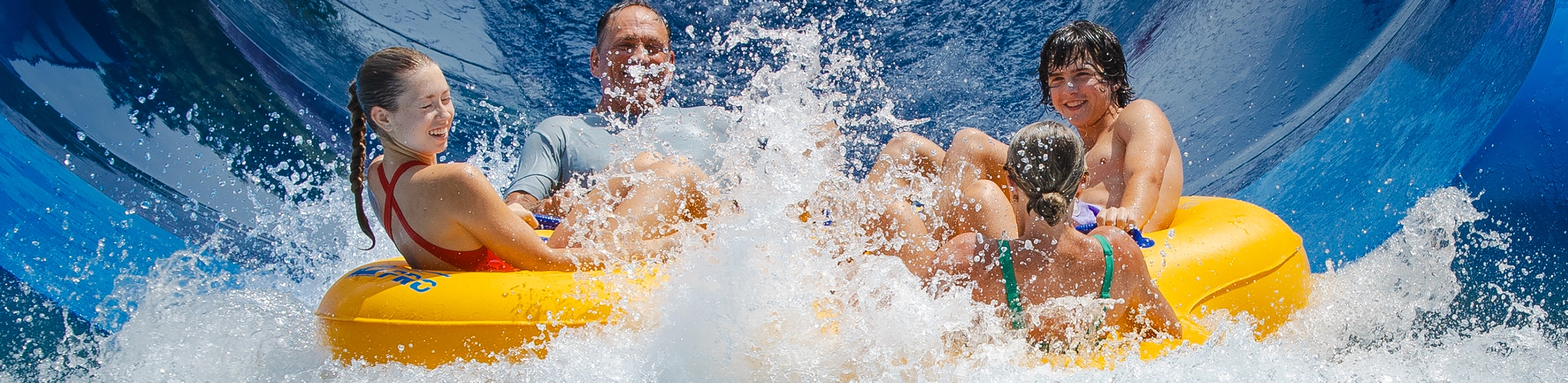 A family splashes down in the pool while riding Zinga.